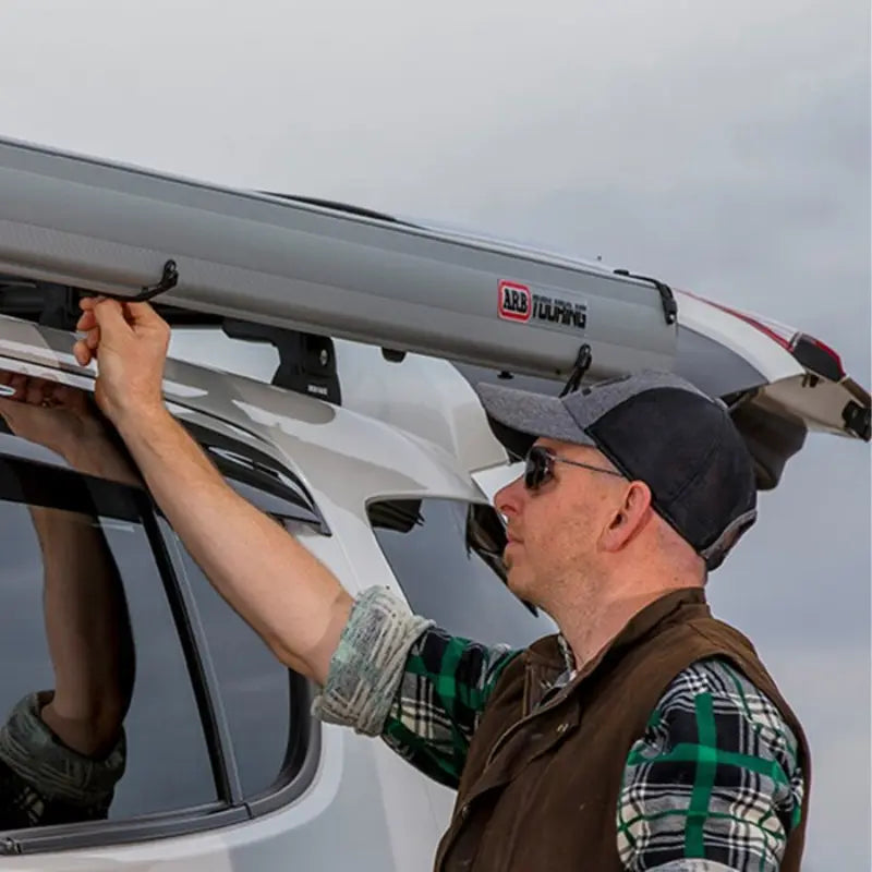 ARB Aluminium Awning With Led Light Kit Man closing the clips on the AWning