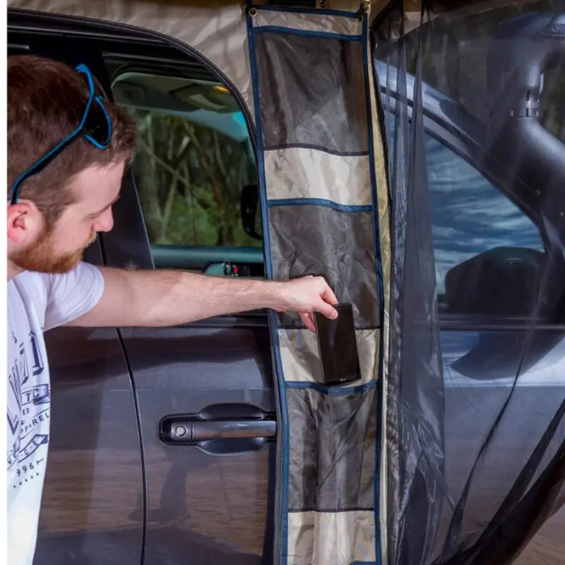 ARB Deluxe Awning Room Including Floor Man Using Storage Pockets