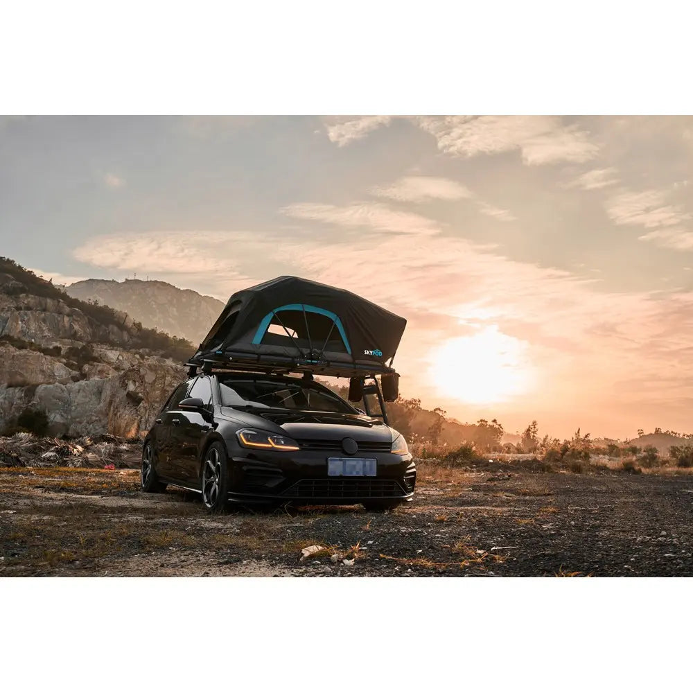 The SkyPod Lite Rooftop Tent Set up on car front view with sun setting in the background