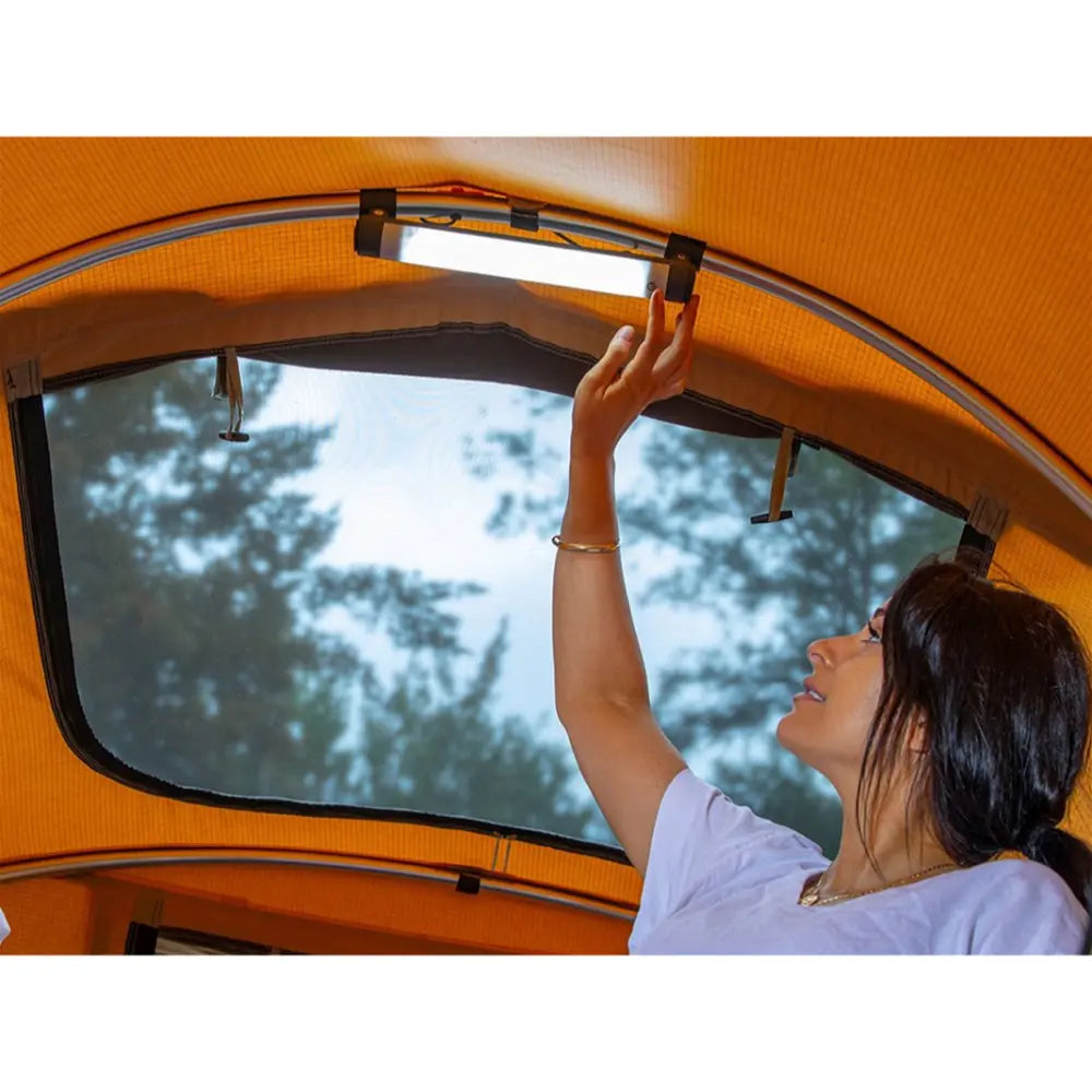 a woman using the ARB tent light inside the flinders tent